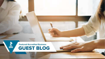 Image of women in white shirt typing and taking notes.