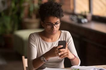 young woman looking at smartphone in confusion