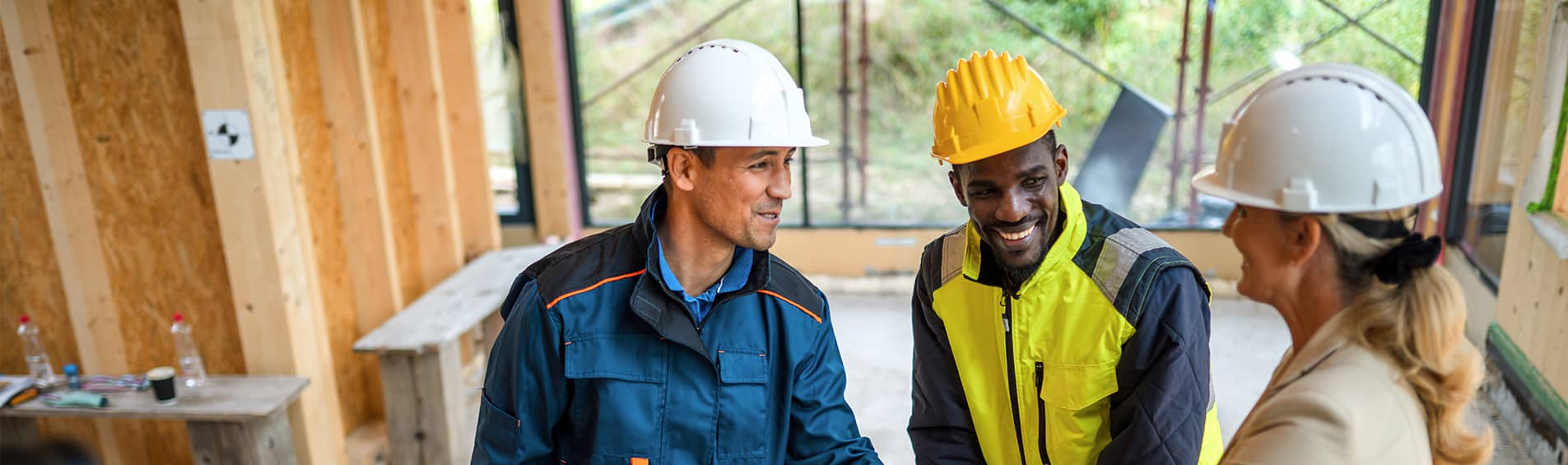Mature female project manager approaches and congratulates male architects for their outstanding work.